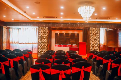 a conference room with black chairs with red bows at Hotel Aavas Inn in Tezpur