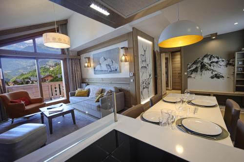 una cucina e un soggiorno con tavolo e sedie di Résidence l'Hévana - Appartements de Prestige Méribel Centre a Méribel