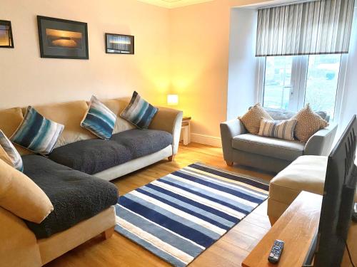 a living room with a couch and a chair at Large House in Looe, Near Beach and Bars with Great Views, Free Parking and Free Access to a Nearby Indoor Swimming Pool in Looe