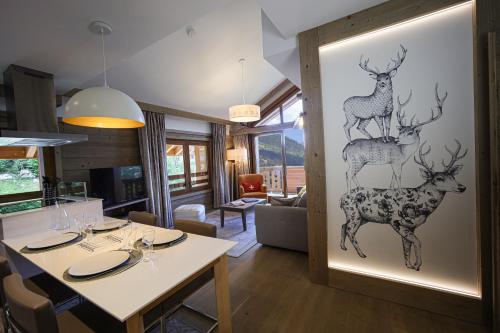 a dining room with a painting of deer on the wall at Résidence l'Hévana - Appartements de Prestige Méribel Centre in Méribel