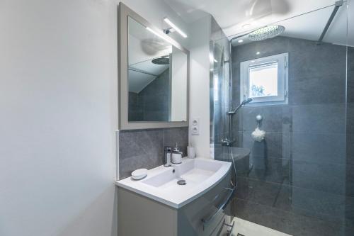een witte badkamer met een wastafel en een douche bij gite de l'ile ste hélène in Pitres