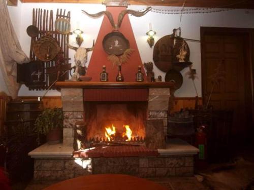a fireplace in a living room with a fire at Arhontiko in Psarades