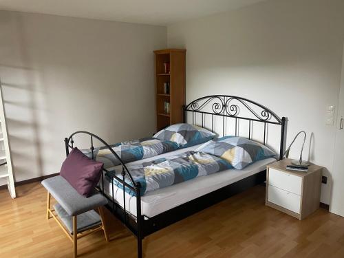 un letto con cuscini e una sedia in una stanza di Ferien im Westerwald a Quirnbach