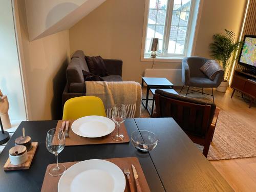 een woonkamer met een eettafel en stoelen bij Nice apartment close to the sea with parking and garden in Arendal