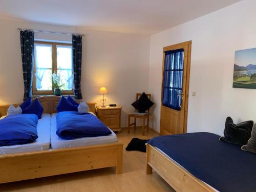 een slaapkamer met 2 bedden en blauwe kussens bij Haus Mona **** in Bad Heilbrunn