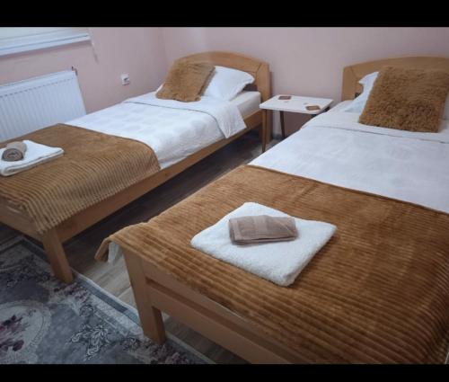 a room with two beds and a table with towels at Apartman i sobe Milica Vrnjacka Banja in Vrnjci