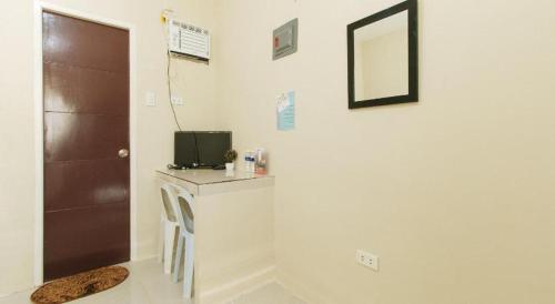 a room with a door and a television on a wall at DMS Apartelle in Los Baños