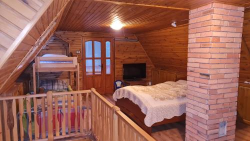 ein Schlafzimmer mit einem Bett in einer Holzhütte in der Unterkunft MÁTRAHÁZ in Galyatető