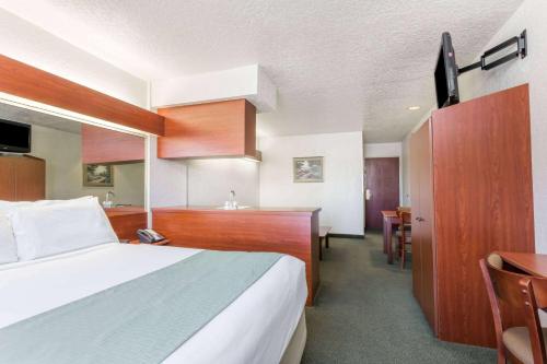 a hotel room with a bed and a kitchen at Microtel Inn & Suites Marianna in Marianna