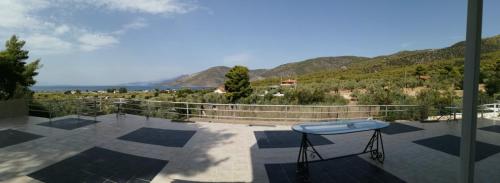 a table on a balcony with mountains in the background at Ioannidis apartment in Psatha