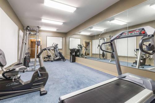 a gym with several treadmills and elliptical machines at Baymont by Wyndham Noblesville in Noblesville