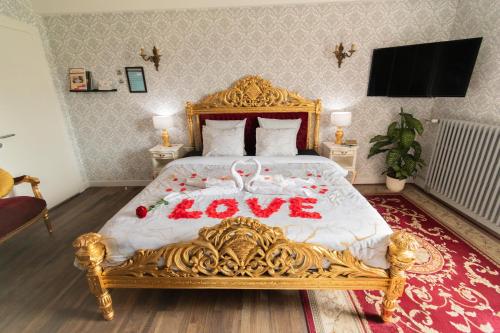 a bedroom with a gold bed with a love sign on it at Private & Comfortable Apartments in Puttelange-aux-Lacs