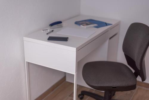 a white desk with a black chair next to it at Private & Comfortable Apartments in Puttelange-aux-Lacs