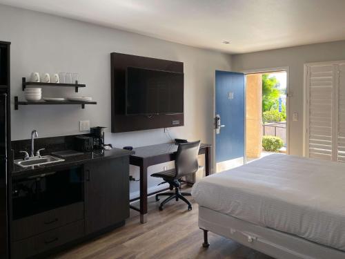 a bedroom with a bed and a desk and a sink at Studio 6 Vallejo CA Napa Valley in Vallejo