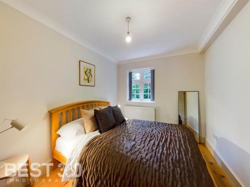 a bedroom with a bed and a window at Redhill town centre apartment by Livingo in Redhill