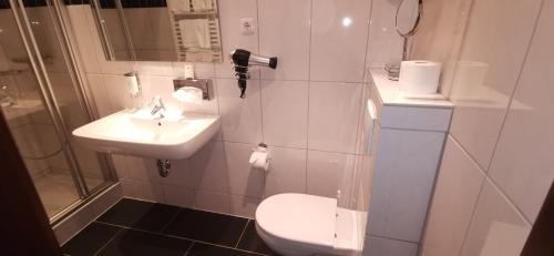 a bathroom with a toilet and a sink and a shower at Heidehotel Soltauer Hof in Soltau