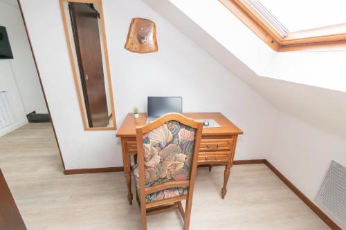a desk with a chair and a wooden table at Private & Comfortable Apartments in Puttelange-aux-Lacs