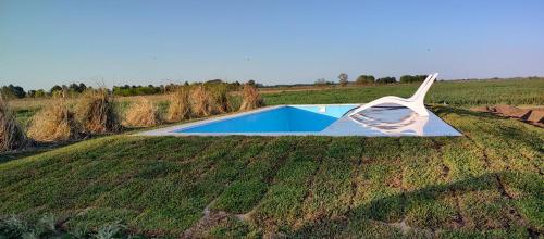 a swimming pool in the middle of a field at Cabaña Rural El Encuentro in San Antonio de Areco
