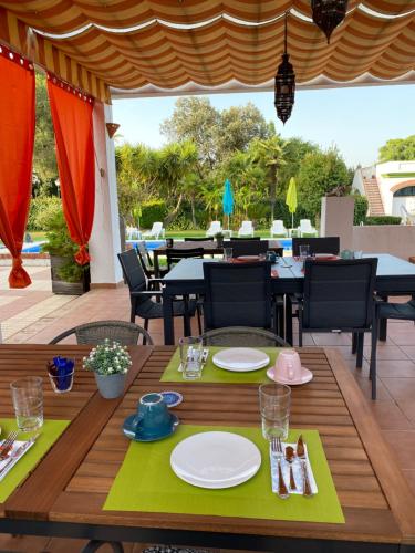 een tafel met borden en keukengerei op een patio bij Devmani Hotel Rural in Espartinas