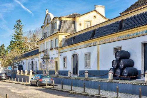 a car parked in front of a building with large black tires at Zimbra Blue Apartment in Sesimbra
