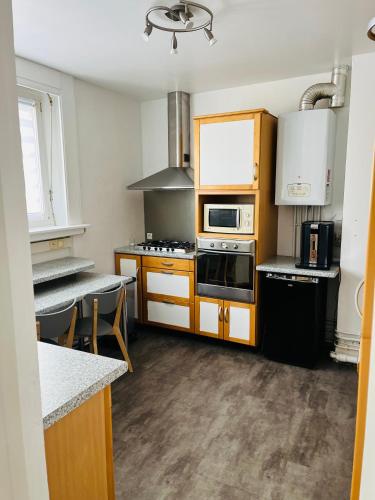 une cuisine avec des armoires en bois et un four à plaques de cuisson dans l'établissement Le Debussy Hyper centre avec parking, à Boulogne-sur-Mer