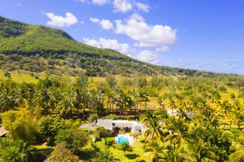 an aerial view of a resort with a pool and a mountain at La Cocoteraie in Le Morne
