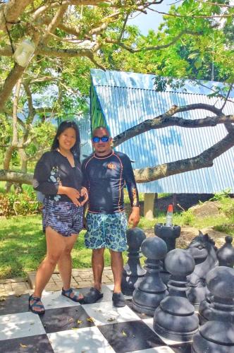 a man and a woman standing on a chess board at House of TamSe Laagans ' Inn in Badian