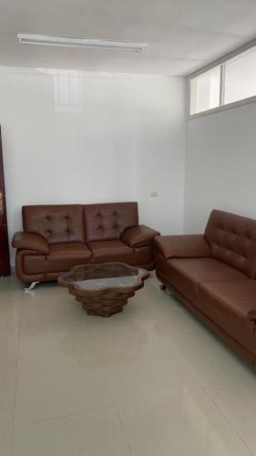 希布倫的住宿－Appartement in Hebron Palestine，客厅配有2张棕色皮沙发和1张桌子