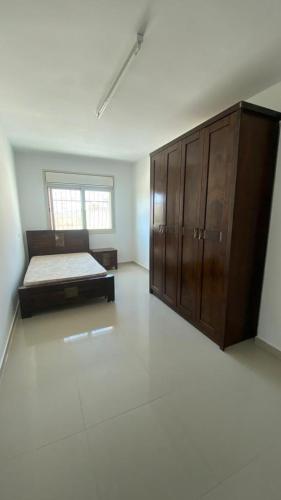 - une chambre avec un lit et une armoire en bois dans l'établissement Appartement in Hebron Palestine, à Hébron