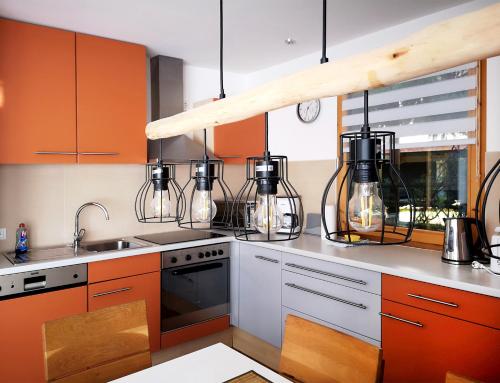 una cocina con armarios y electrodomésticos de color naranja y blanco en Ferienhaus DANA, en Meschede