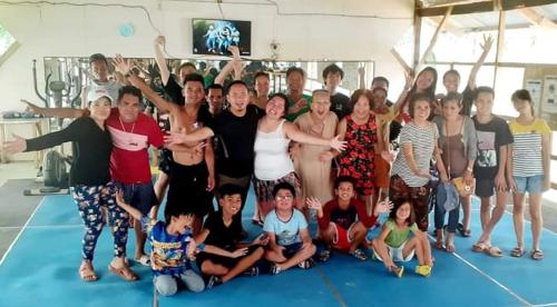 a group of people posing for a picture in a gym at House of TamSe Laagans ' Inn in Badian