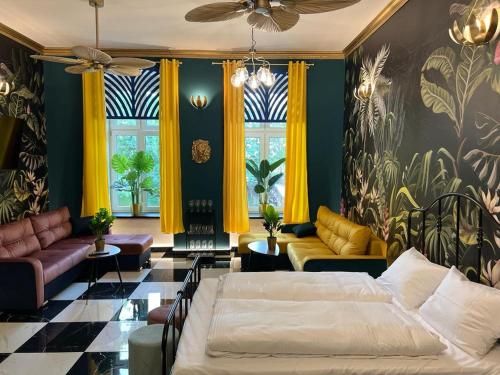 a living room with two beds and yellow curtains at Jungle Apartments in Wrocław