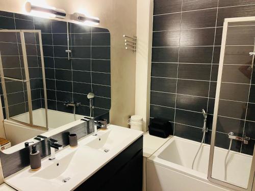 une salle de bain avec un lavabo, un miroir et une baignoire dans l'établissement Le Debussy Hyper centre avec parking, à Boulogne-sur-Mer