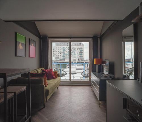 a living room with a couch and a large window at Tiny Floating Home with Marina Views in Brighton & Hove