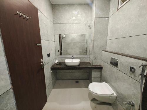 a bathroom with a toilet and a sink at Radha Residency in Satna