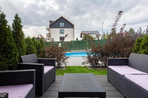 a patio with chairs and a pool and a house at Martinus Apartments in Mechelinki