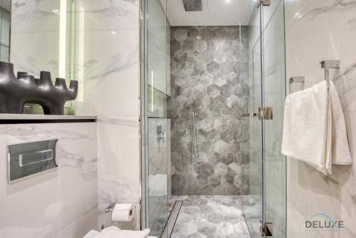 a bathroom with a shower with a glass door at Urban Studio at MAG 318 Business Bay by Deluxe Holiday Homes in Dubai