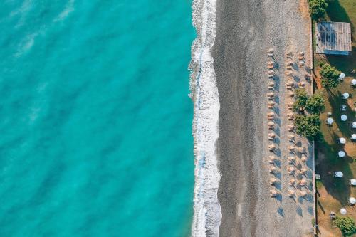 una vista aerea di una spiaggia con un gruppo di auto parcheggiate di Giannoulis – Cavo Spada Luxury Sports & Leisure Resort & Spa a Kolymvari