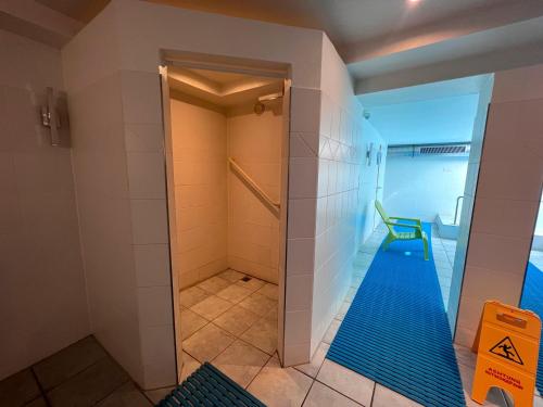 uma casa de banho com cabina de duche ao nível do chão e piso azul em Nordland Appartements - Wohnung Lolland em Wyk auf Föhr