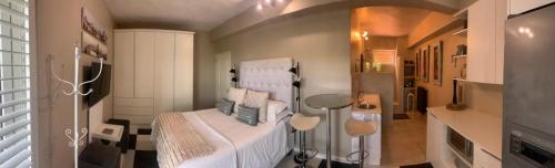 a bedroom with a bed with white sheets and pillows at Home Suite Hout Bay in Cape Town