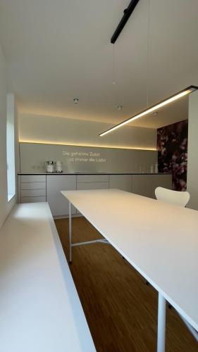 a white kitchen with a white table and chairs at Moselfreude in Cochem