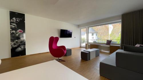 a living room with a red chair and a couch at Moselfreude in Cochem