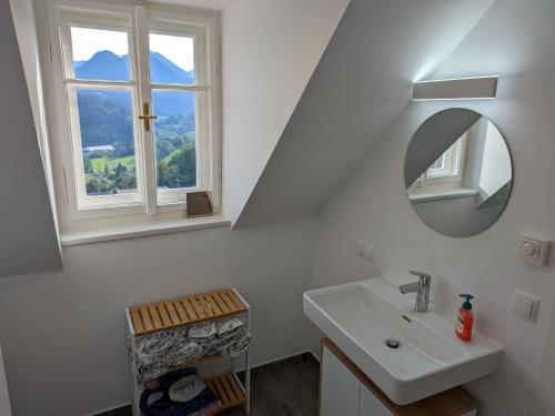 Apartment in Mariazell near ski area في ماريازيل: حمام مع حوض ومرآة ونافذة