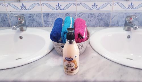 a bathroom with two sinks and a bottle of toothbrushes at Maison plain-pied avec piscine chauffée in Tunis