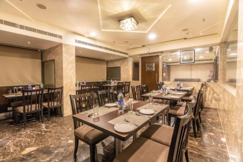 a restaurant with tables and chairs in a room at Cygnett Inn Ramachandra in Kurmannapalem