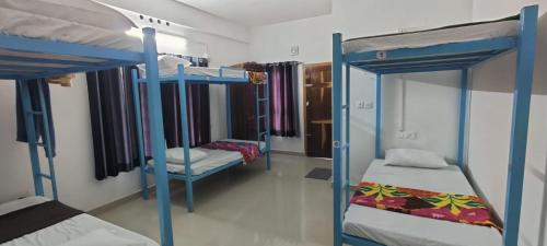 a room with two bunk beds and a room with two beds at 3R Residency Munnar in Munnar