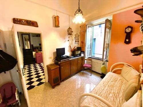 ein Wohnzimmer mit einem Sofa und einem Schreibtisch mit einem TV in der Unterkunft La casa dell'Infanta - Finalborgo in Finale Ligure