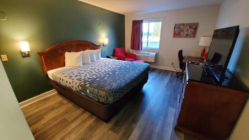 a hotel room with a bed and a television at Stonewood Inn & Suites of Carrollton - Smithfield in Carrollton