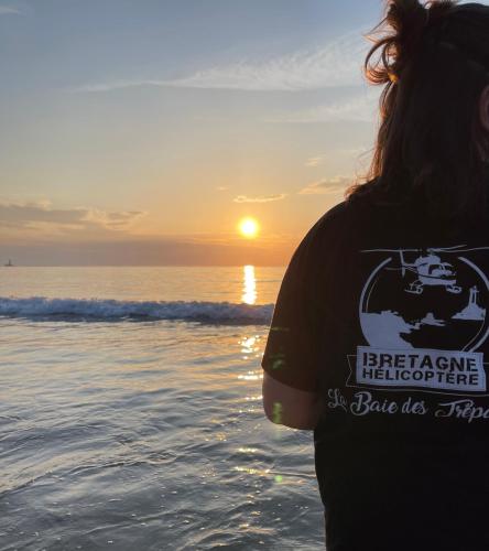 a woman standing on the beach watching the sunset at Hôtel de la Baie des Trépassés in Plogoff