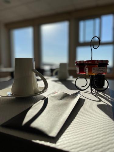 a coffee cup and a candle on a table at Hôtel de la Baie des Trépassés in Plogoff